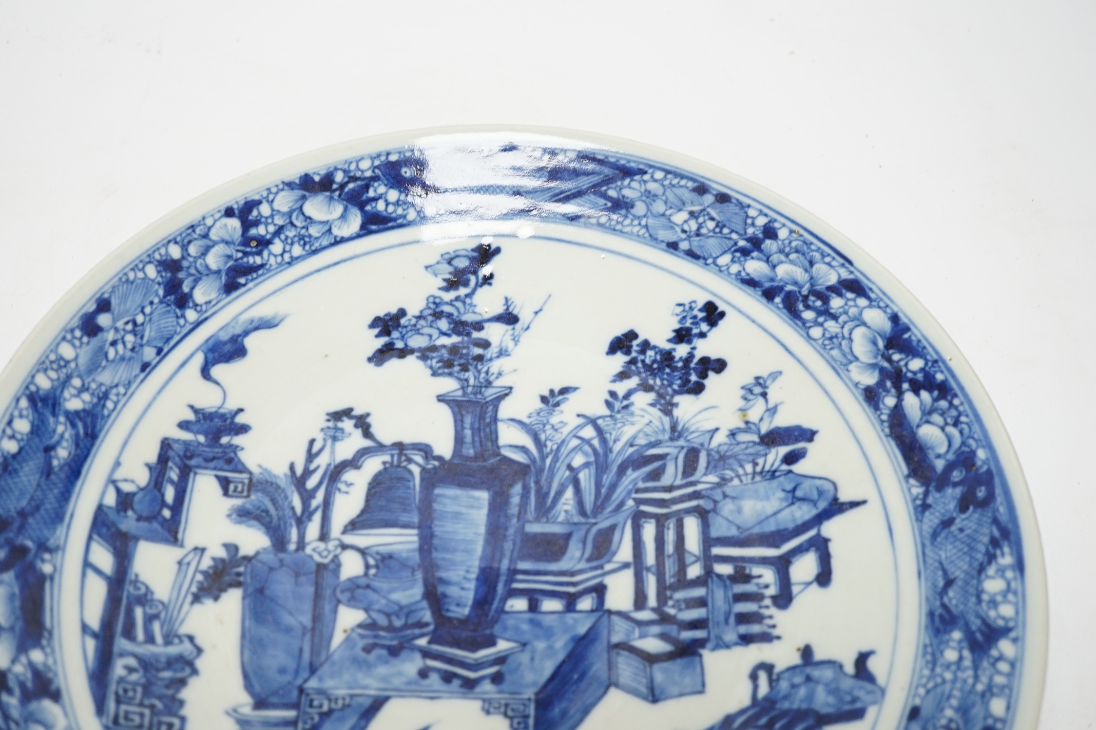 A 19th century Chinese blue and white ‘Hundred Antiques’ dish, with fish to the border, 30cm in diameter